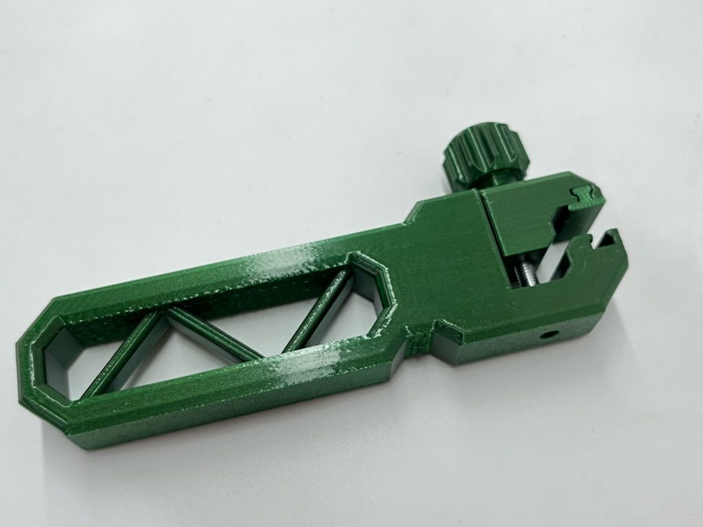 Red PETG print of a functional mechanical part.